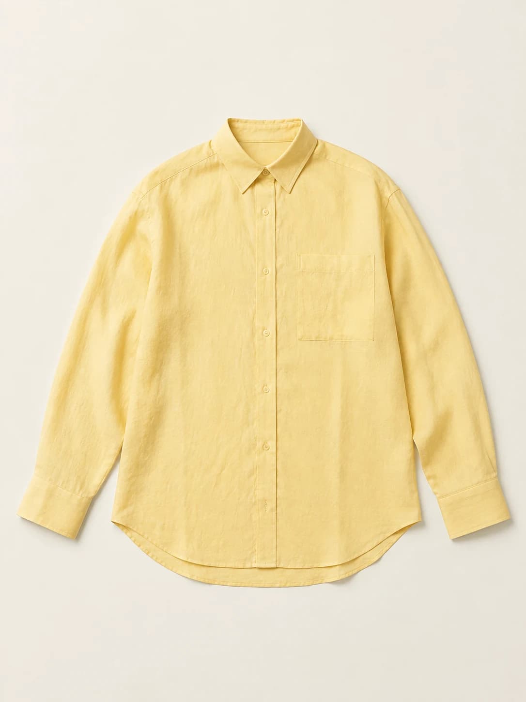 Illustrative flat-lay arrangement of a yellow linen shirt with its neckline, buttons and sleeves visible